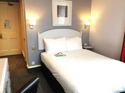 a hotel room with a bed and a door at Millennium Hotel Glasgow in Glasgow