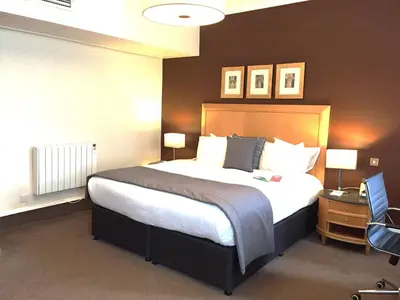 a hotel room with a bed and a desk with a computer at Millennium Hotel Glasgow in Glasgow