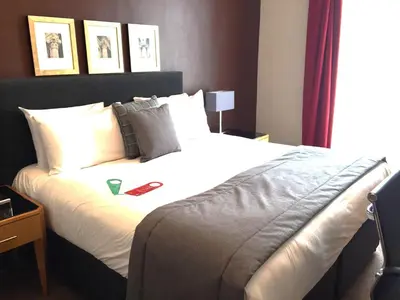 a bedroom with a large bed with white sheets at Millennium Hotel Glasgow in Glasgow