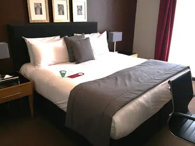 a bedroom with a large bed with white sheets and pillows at Millennium Hotel Glasgow in Glasgow