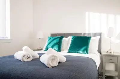 a bed with towels on top of it at Beautiful Glasgow South Home - Pass the Keys in Glasgow