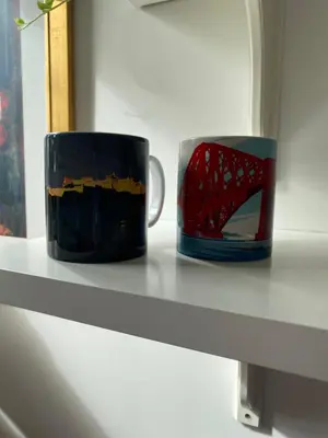 two coffee mugs sitting on a shelf at Tranquil Haven Murrayfield in Edinburgh