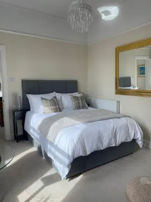 a bedroom with a large bed and a mirror at Tranquil Haven Murrayfield in Edinburgh