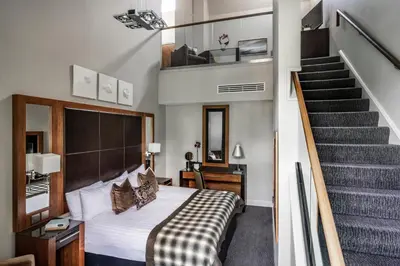 a hotel room with a bed and a staircase at Norton House Hotel & Spa, Edinburgh in Ingliston