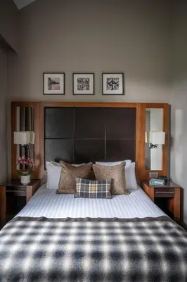 a bedroom with a large bed with a large headboard at Norton House Hotel & Spa, Edinburgh in Ingliston
