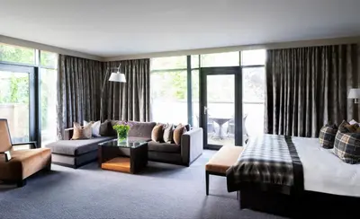 a living room with a bed and a couch and a living room at Norton House Hotel & Spa, Edinburgh in Ingliston