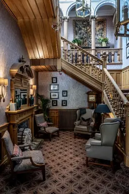 a lobby with a staircase and chairs and a stair case at Norton House Hotel & Spa, Edinburgh in Ingliston