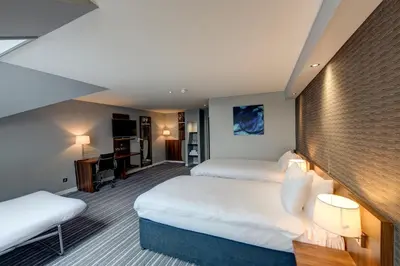 a hotel room with two beds and a desk at Holiday Inn Express Edinburgh Airport by IHG in Ingliston