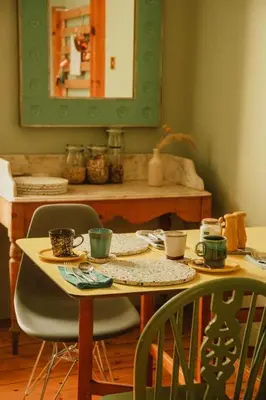 a table with two chairs and a mirror at Ben A'an House in Callander