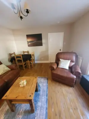 a living room with leather furniture and a coffee table at 2 Kilkerran Road in Campbeltown
