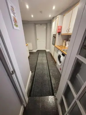 a hallway of a kitchen with a washer and dryer at 2 Kilkerran Road in Campbeltown