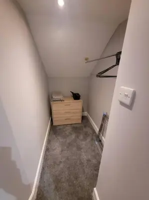 an attic room with a wooden dresser in a room at 2 Kilkerran Road in Campbeltown