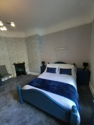 a bedroom with a large bed with two blue pillows at The Nifty Nook in Campbeltown