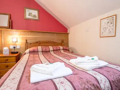 a bedroom with two beds with towels on them at Corstorphine Lodge Hotel in Edinburgh