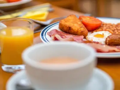 a plate of breakfast food and a cup of coffee at Corstorphine Lodge Hotel in Edinburgh