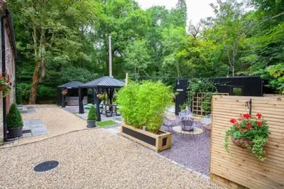 a garden with a wooden fence and a gazebo at The Ultimate Luss Retreat in Luss