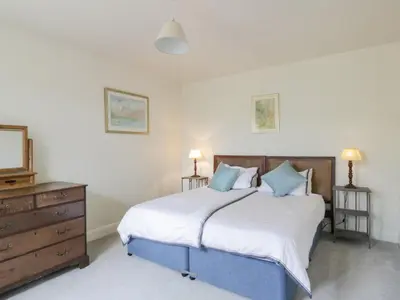 a bedroom with a large bed and a dresser at Prince's Cottage in Thornhill