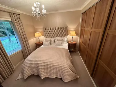 a bedroom with a large bed and a window at One Dunbar Court Gleneagles Village in Auchterarder