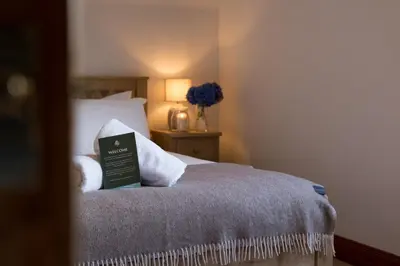 a bedroom with a bed with a book on it at Woodlands House with Hot Tub in Ballachulish