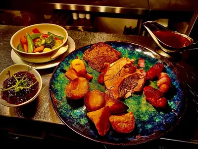 a plate of food with meat and vegetables on a table at The Horseshoe in Lochgilphead