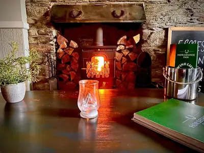 a glass vase sitting on a table with a fireplace at The Horseshoe in Lochgilphead