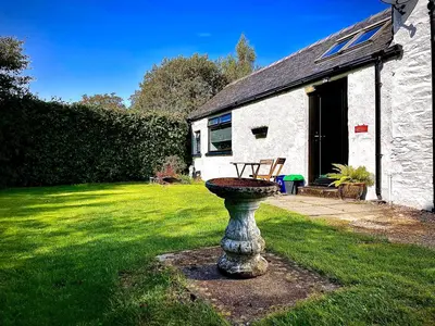 a stone birdbath in the yard of a house at The Horseshoe in Lochgilphead