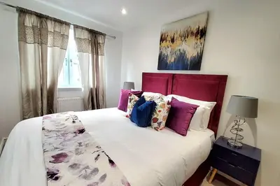 a bedroom with a large bed with purple pillows at Three Bedrooms House By Sensational Stay Short Lets & Serviced Accommodation With Free Parking & Wi-fi in Ballingry