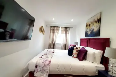 a bedroom with a bed with white sheets and purple pillows at Three Bedrooms House By Sensational Stay Short Lets & Serviced Accommodation With Free Parking & Wi-fi in Ballingry