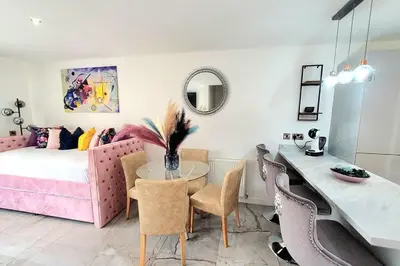 a living room with a table and a pink couch at Three Bedrooms House By Sensational Stay Short Lets & Serviced Accommodation With Free Parking & Wi-fi in Ballingry