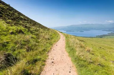 a dirt road on the side of a grassy hill at Luxury Guest House Getaway for 2 in Drymen