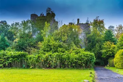 a castle in the middle of a green field at Luxury Guest House Getaway for 2 in Drymen
