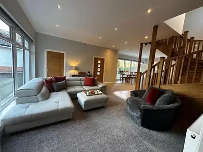 a living room with a couch and chairs and a staircase at Luxury Guest House Getaway for 2 in Drymen