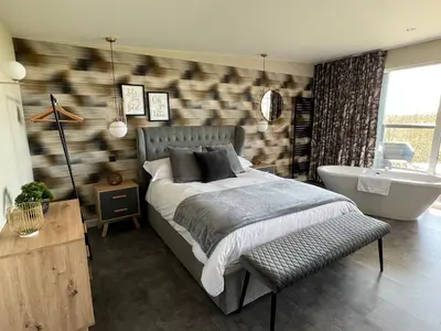 a bedroom with a bed and a bath tub at Loudoun Mains Luxury Lodges in Newmilns