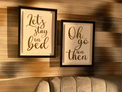two framed pictures on a wooden wall with words at Loudoun Mains Luxury Lodges in Newmilns
