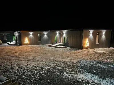 a house at night with a dirt yard at Loudoun Mains Luxury Lodges in Newmilns