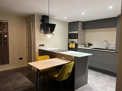 a kitchen with a table and some yellow chairs at Loudoun Mains Luxury Lodges in Newmilns
