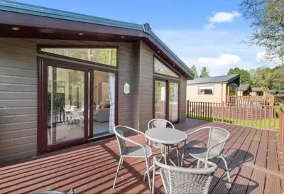a deck with a table and chairs on a house at Rivers Edge in Dollar