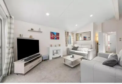 a living room with a couch and a flat screen tv at Rivers Edge in Dollar