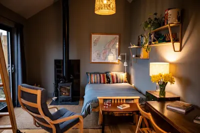 a bedroom with a bed and a table and a desk at Jura - The Black Hut in Isle of Jura