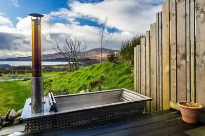 a bath tub sitting on top of a wooden deck at Jura - The Black Hut in Isle of Jura