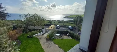 an aerial view of a house with a view of the ocean at The Villa Farmhouse in Cushendun