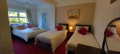 a hotel room with two beds and a window at The Villa Farmhouse in Cushendun