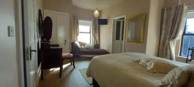 a hotel room with a bed and a living room at The Villa Farmhouse in Cushendun