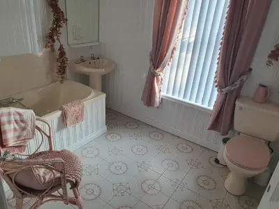 a bathroom with a tub and a toilet and a sink at The Villa Farmhouse in Cushendun