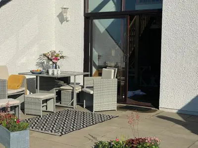 a patio with a table and chairs next to a building at Lanfine View 1 at Loudoun Mains with Hot Tub in Newmilns