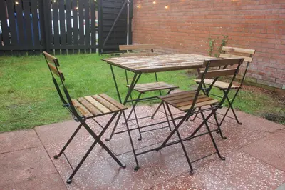a wooden table and chairs sitting next to a yard at Peaceful house in the heart of Glasgow city, close to Queen Elizabeth Hospital and Govan subway, Free Private Parking in Glasgow