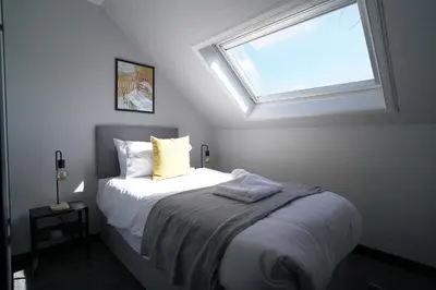 a bedroom with a bed with a window above it at Sauchie House in Sauchie