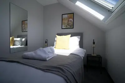 a bedroom with a large bed with a skylight at Sauchie House in Sauchie