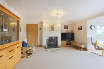 a living room with a fireplace and a tv at Teapot Cottage in Newton Stewart