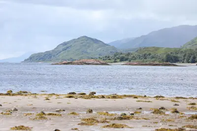 a body of water with mountains in the background at Clovullin Croftview Pod in Ardgour